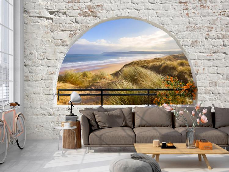 Fototapeta Widok z okna - pejzaż z morzem i piaszczystą plażą otoczony cegłą